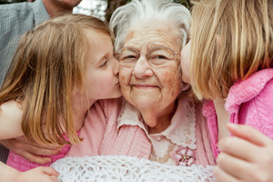 A grandmother being kissed by grandchildren